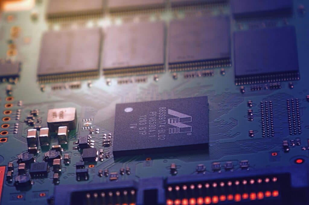 Close-up of a circuit board with a large chip and small components (stock photo, to be replaced)